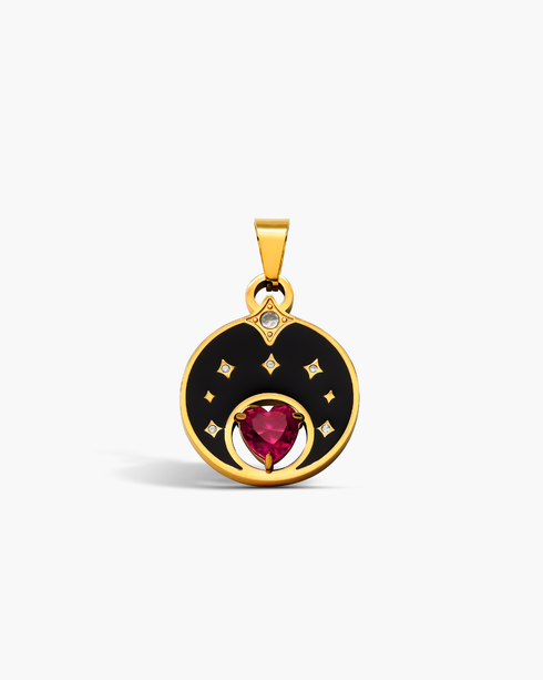 Gold pendant with a red gemstone and black enamel design on a white background