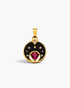 Gold pendant with a red gemstone and black enamel design on a white background